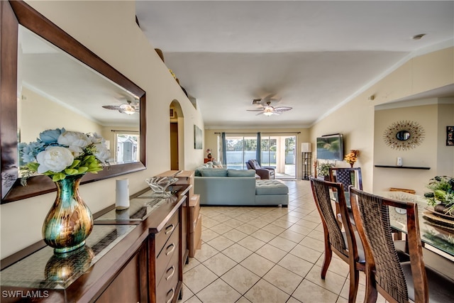 tiled living room featuring lofted ceiling, ceiling fan, and ornamental molding