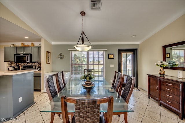 dining area with crown molding and light tile patterned flooring