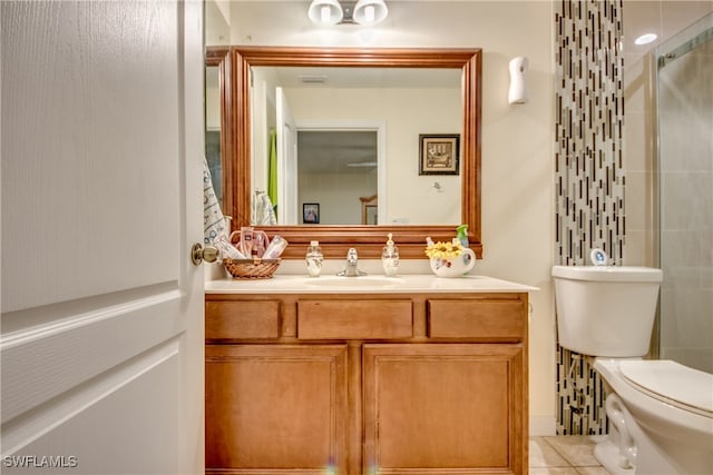 bathroom featuring tile patterned floors, vanity, toilet, and walk in shower