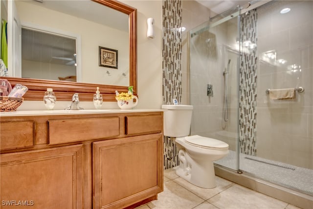 bathroom with tile patterned floors, vanity, toilet, and a shower with shower door