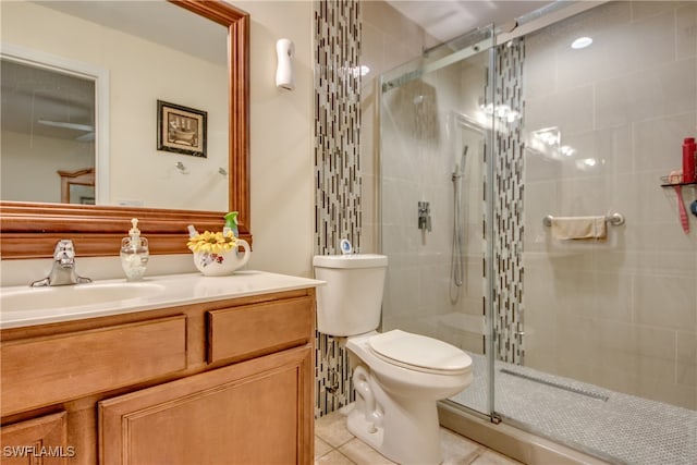 bathroom with toilet, tile patterned flooring, vanity, and walk in shower