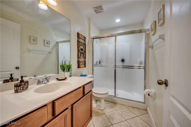 bathroom with tile patterned flooring, vanity, toilet, and an enclosed shower