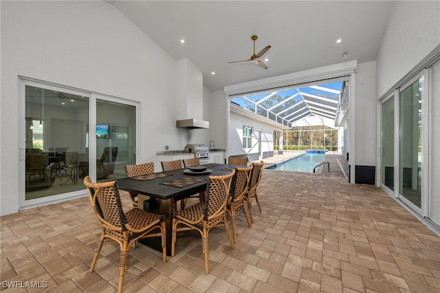 view of patio / terrace featuring ceiling fan, glass enclosure, grilling area, an outdoor pool, and outdoor dining space