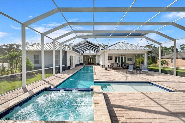 view of pool with an in ground hot tub, a patio, glass enclosure, and ceiling fan