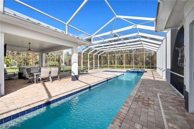 view of swimming pool with an in ground hot tub, a lanai, a patio area, and ceiling fan