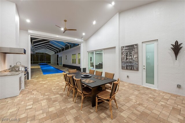 dining room with brick floor, recessed lighting, a sunroom, and high vaulted ceiling