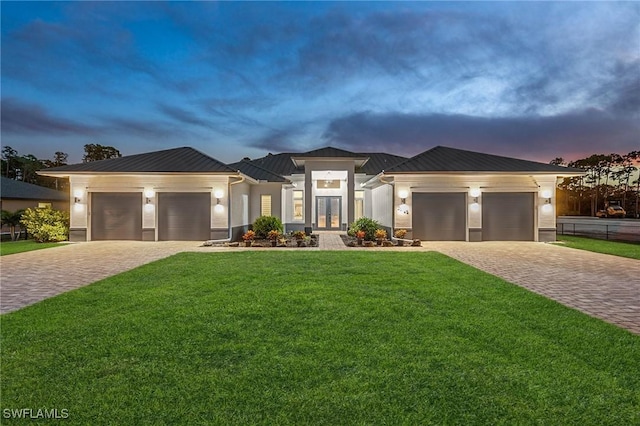 prairie-style home featuring a yard and a garage