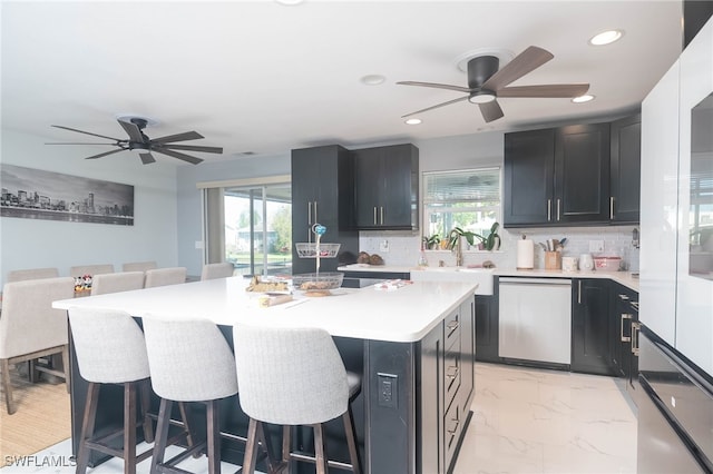 kitchen with a breakfast bar, a wealth of natural light, and dishwasher