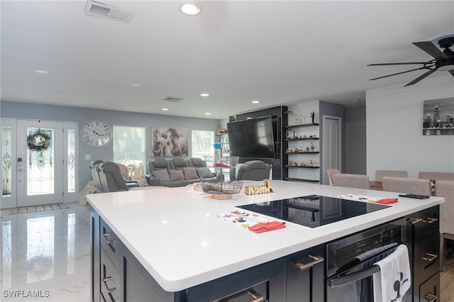 kitchen featuring ceiling fan, black appliances, and a kitchen island