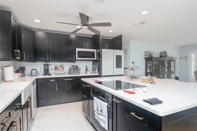 kitchen featuring ceiling fan, appliances with stainless steel finishes, and decorative backsplash