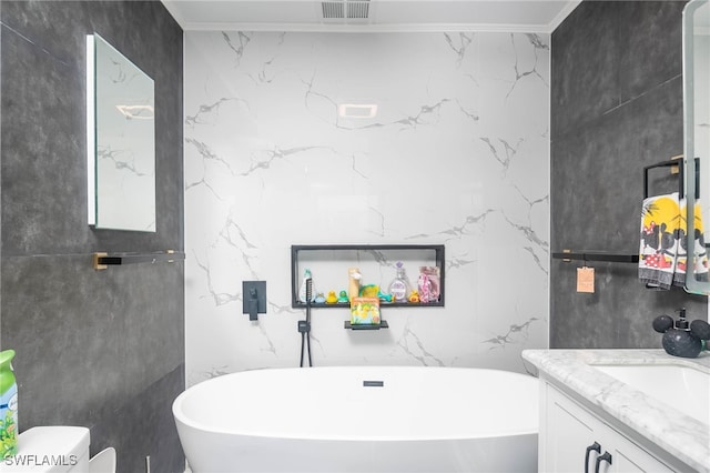 bathroom featuring toilet, a tub, vanity, ornamental molding, and tile walls