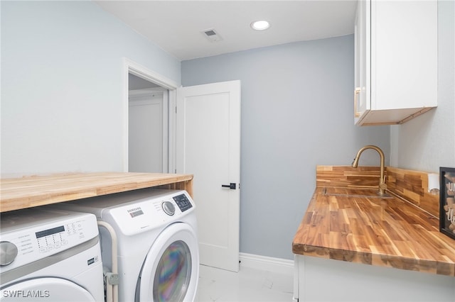 washroom with cabinets, sink, and washer and clothes dryer