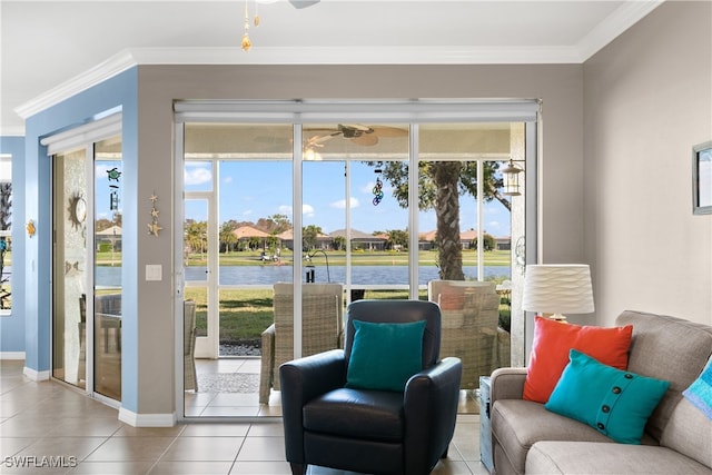 sitting room with a water view, light tile patterned floors, crown molding, and a wealth of natural light