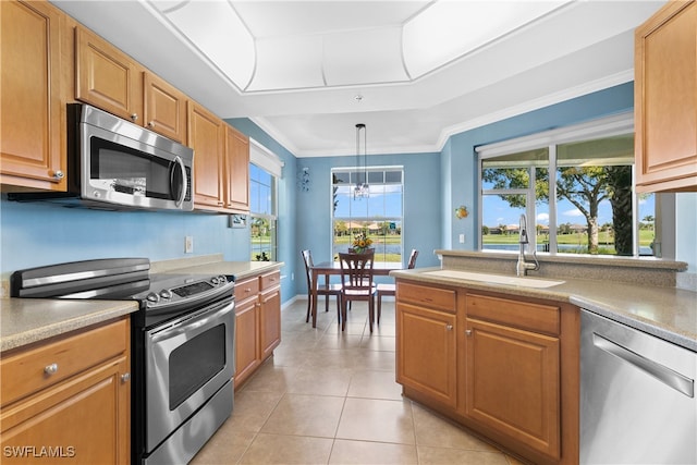 kitchen with appliances with stainless steel finishes, sink, pendant lighting, crown molding, and a notable chandelier