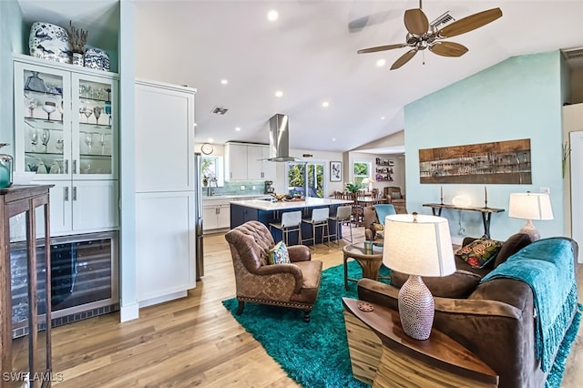 living room with vaulted ceiling, light wood-type flooring, and ceiling fan