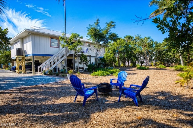 exterior space featuring an outdoor fire pit and central AC unit