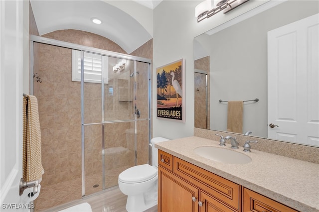 bathroom with toilet, a shower with shower door, vanity, and lofted ceiling