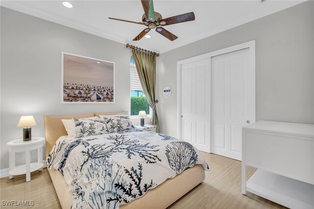 bedroom with ornamental molding, wood-type flooring, a closet, and ceiling fan