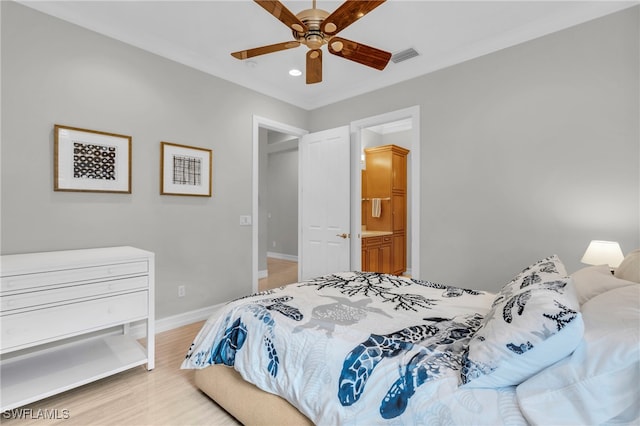 bedroom with light hardwood / wood-style floors, ensuite bathroom, and ceiling fan