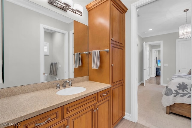 bathroom with vanity, an inviting chandelier, and crown molding