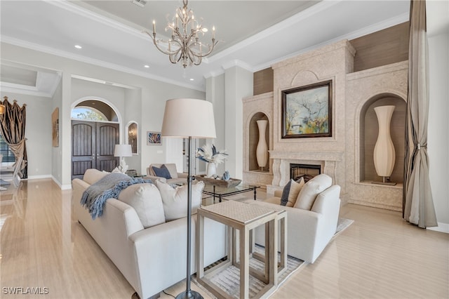 living room featuring crown molding, light hardwood / wood-style flooring, an inviting chandelier, and a high end fireplace