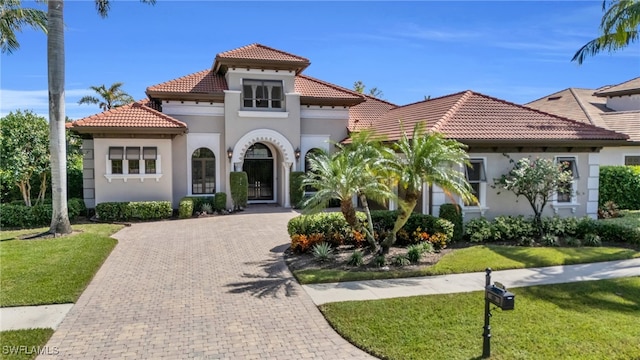 mediterranean / spanish home with a front yard