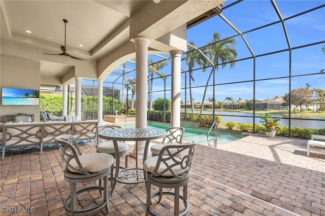 view of patio / terrace with ceiling fan, a water view, and glass enclosure