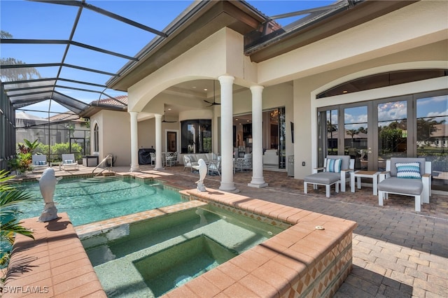 view of pool with an in ground hot tub, a patio area, glass enclosure, and ceiling fan