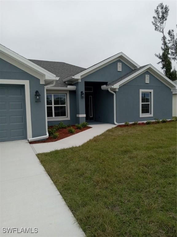 single story home with a garage and a front lawn