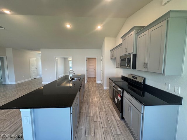 2919 NW 10th St, Cape Coral, FL 33993 - kitchen with appliances with stainless steel finishes, a sink, light wood finished floors, dark countertops, and recessed lighting