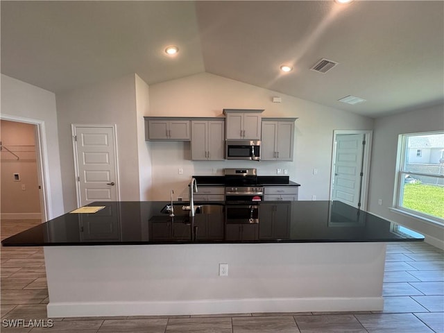 2919 NW 10th St, Cape Coral, FL 33993 - kitchen with appliances with stainless steel finishes, a sink, lofted ceiling, dark countertops, and gray cabinetry