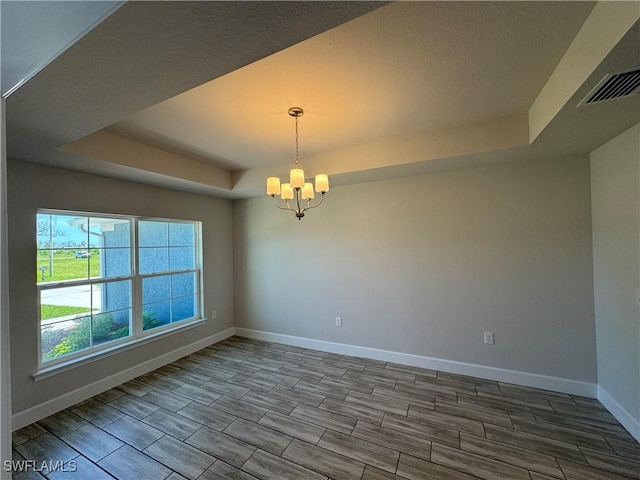 2919 NW 10th St, Cape Coral, FL 33993 - empty room with a tray ceiling, a chandelier, baseboards, and wood finish floors