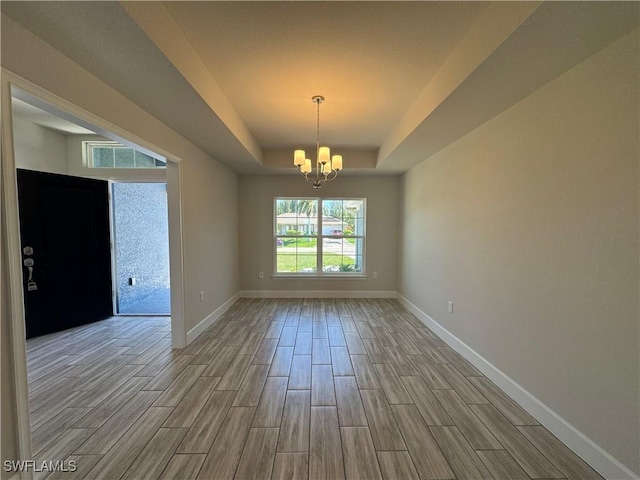 2919 NW 10th St, Cape Coral, FL 33993 - spare room with wood tiled floors, a raised ceiling, a chandelier, and baseboards
