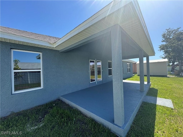 2919 NW 10th St, Cape Coral, FL 33993 - view of side of property featuring a lawn, a patio area, and stucco siding