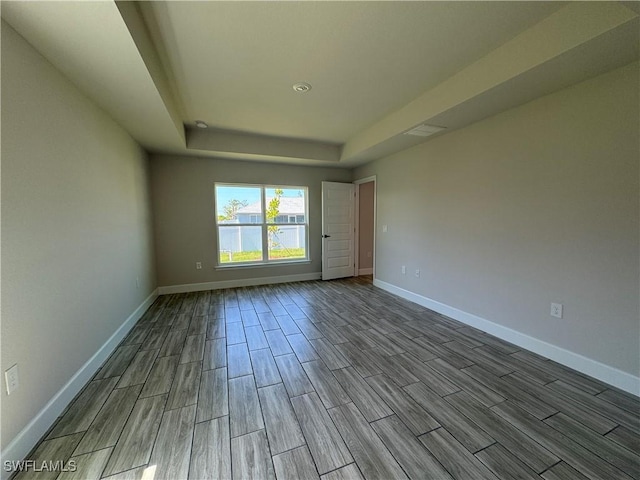 2919 NW 10th St, Cape Coral, FL 33993 - unfurnished room with a raised ceiling, wood finished floors, and baseboards