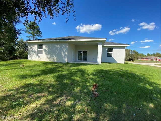 back of property featuring a lawn