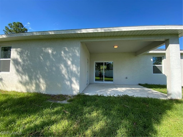 back of property with a patio area and a yard