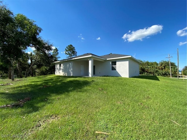 rear view of property featuring a lawn