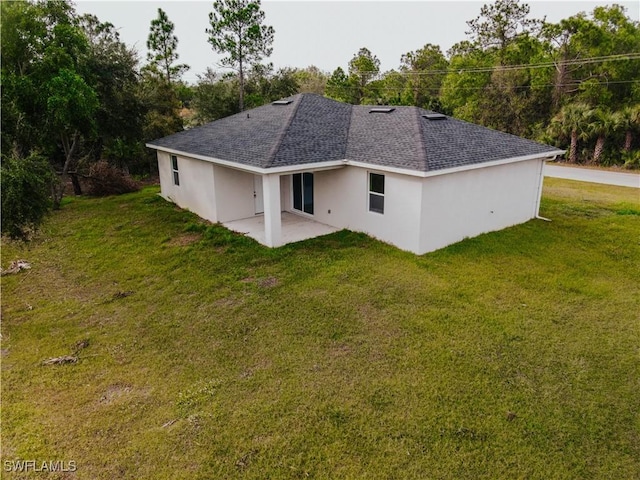 rear view of property featuring a patio area and a lawn