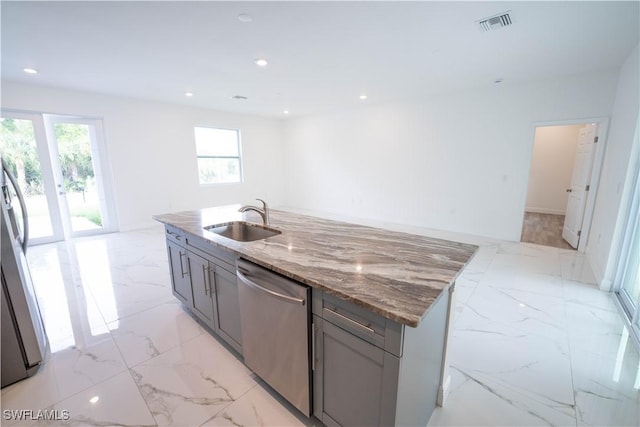 kitchen with dishwasher, sink, an island with sink, stone countertops, and gray cabinets