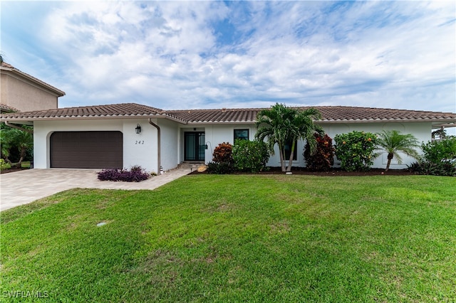 mediterranean / spanish-style house featuring a front yard and a garage