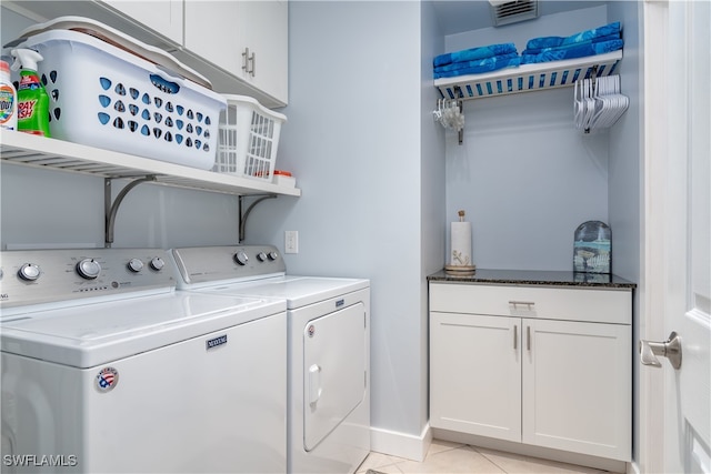 clothes washing area featuring light tile patterned flooring, cabinets, and independent washer and dryer