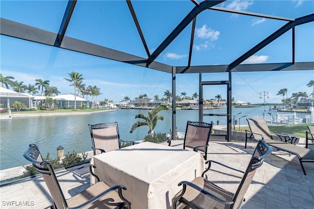 view of patio with glass enclosure and a water view