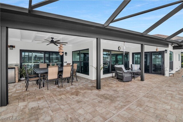 view of patio featuring ceiling fan and a lanai