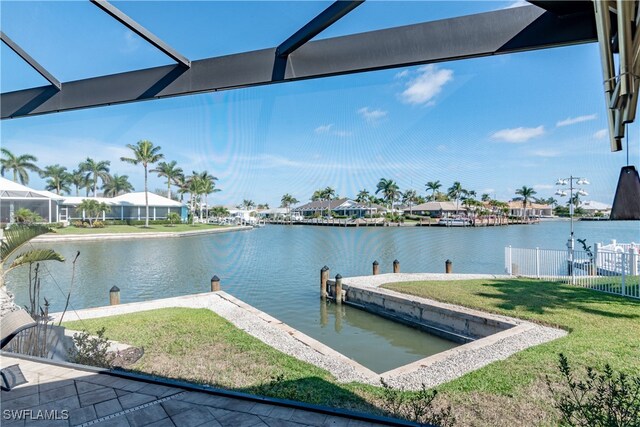 view of dock featuring a lawn and a water view