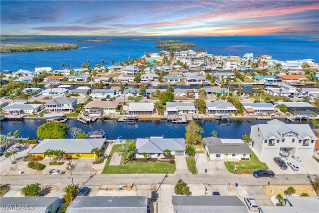 aerial view at dusk featuring a water view