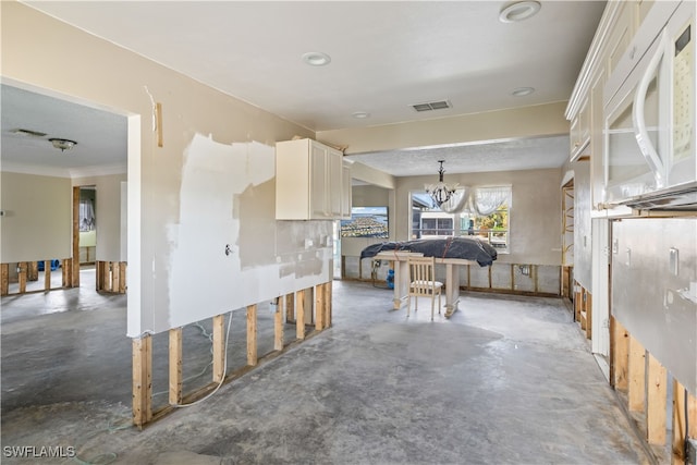 kitchen with ornamental molding, white cabinets, a chandelier, and decorative light fixtures