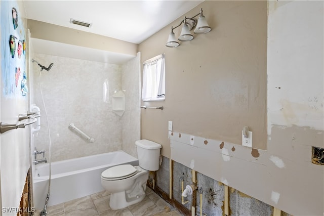 bathroom with tiled shower / bath combo and toilet