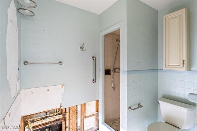 bathroom featuring toilet, tile walls, and tiled shower