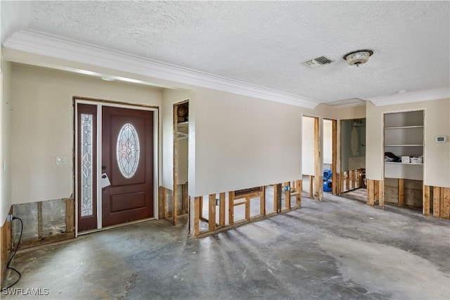 entrance foyer featuring ornamental molding, concrete floors, and a textured ceiling